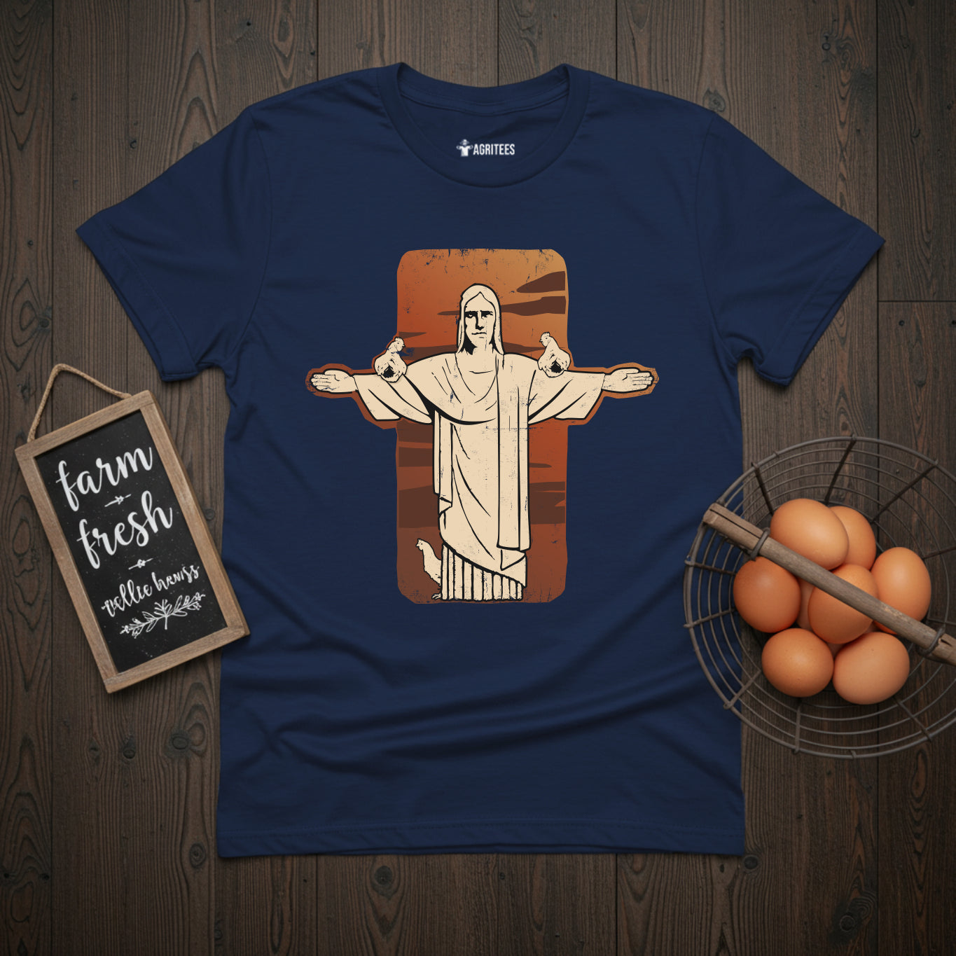T-shirt featuring stylized illustration of the Christ the Redeemer statue from Rio de Janeiro with chickens perched on its outstretched arms, set against a rust-colored background on navy fabric, blending iconic landmark imagery with chicken keeping themes.