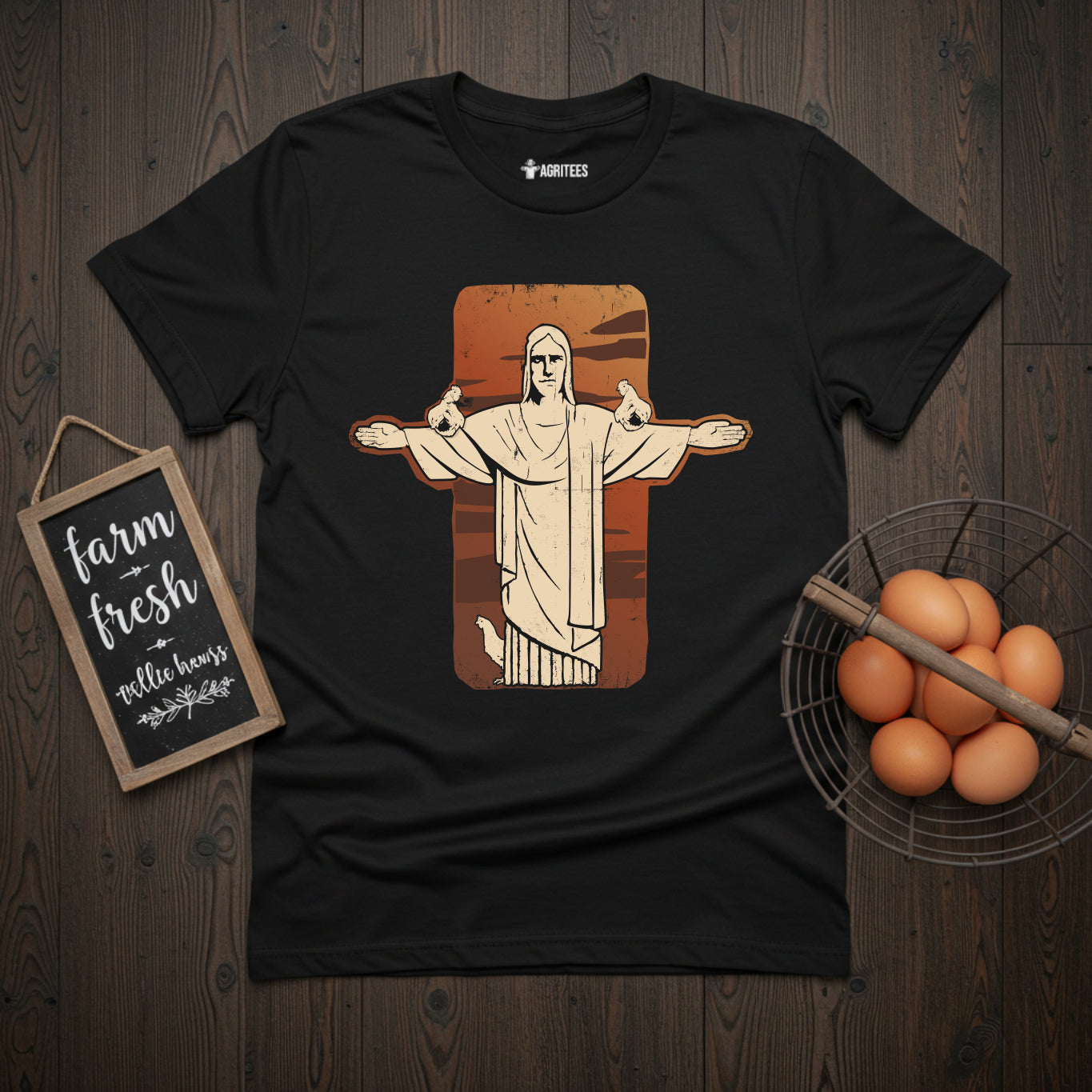 T-shirt featuring stylized illustration of the Christ the Redeemer statue from Rio de Janeiro with chickens perched on its outstretched arms, set against a rust-colored background on black fabric, blending iconic landmark imagery with chicken keeping themes.